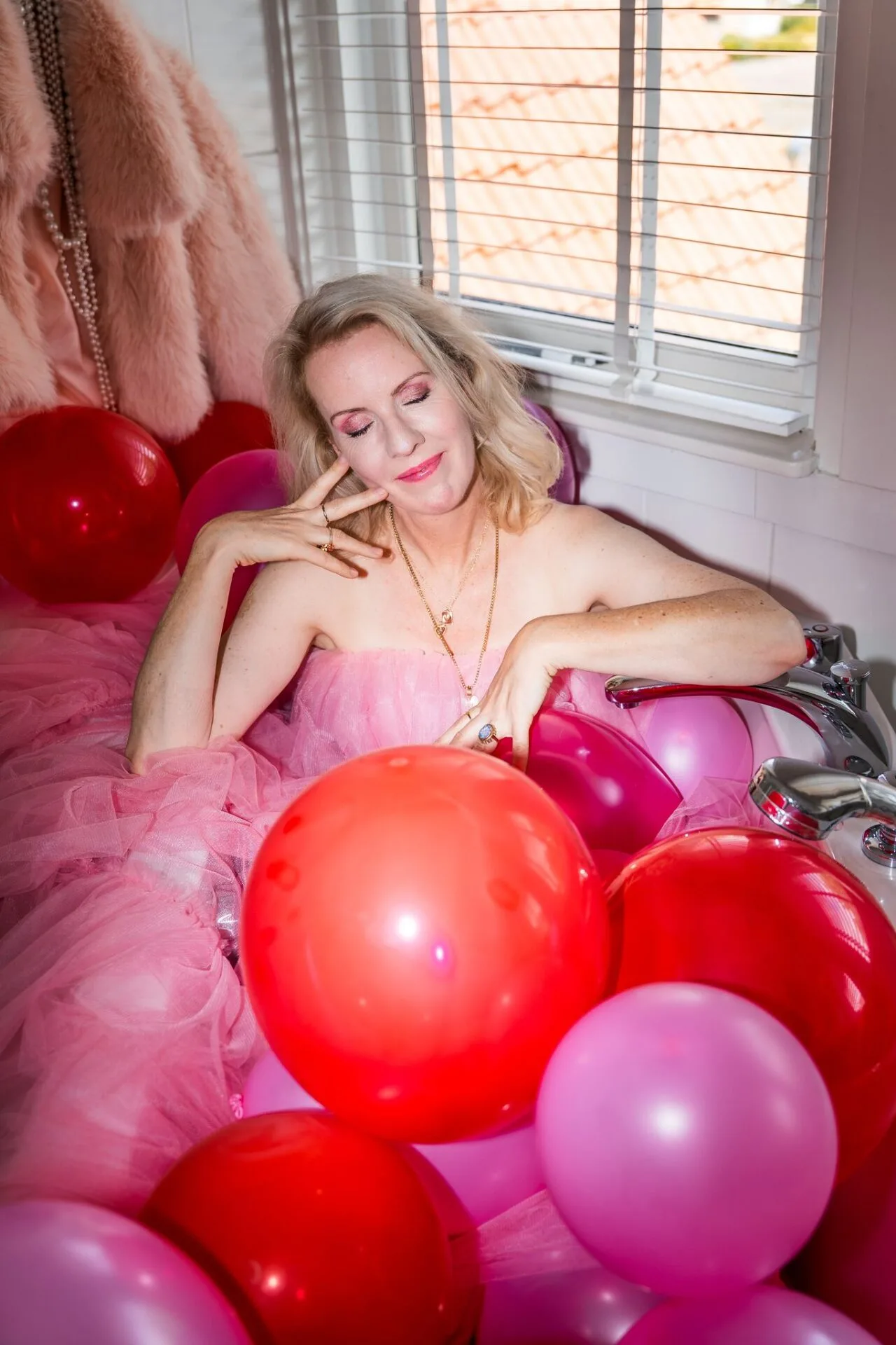 Minke Maat, dichter en joyfluencer in een bad vol ballonnen voor inspiratie - foto Jantasie Studio